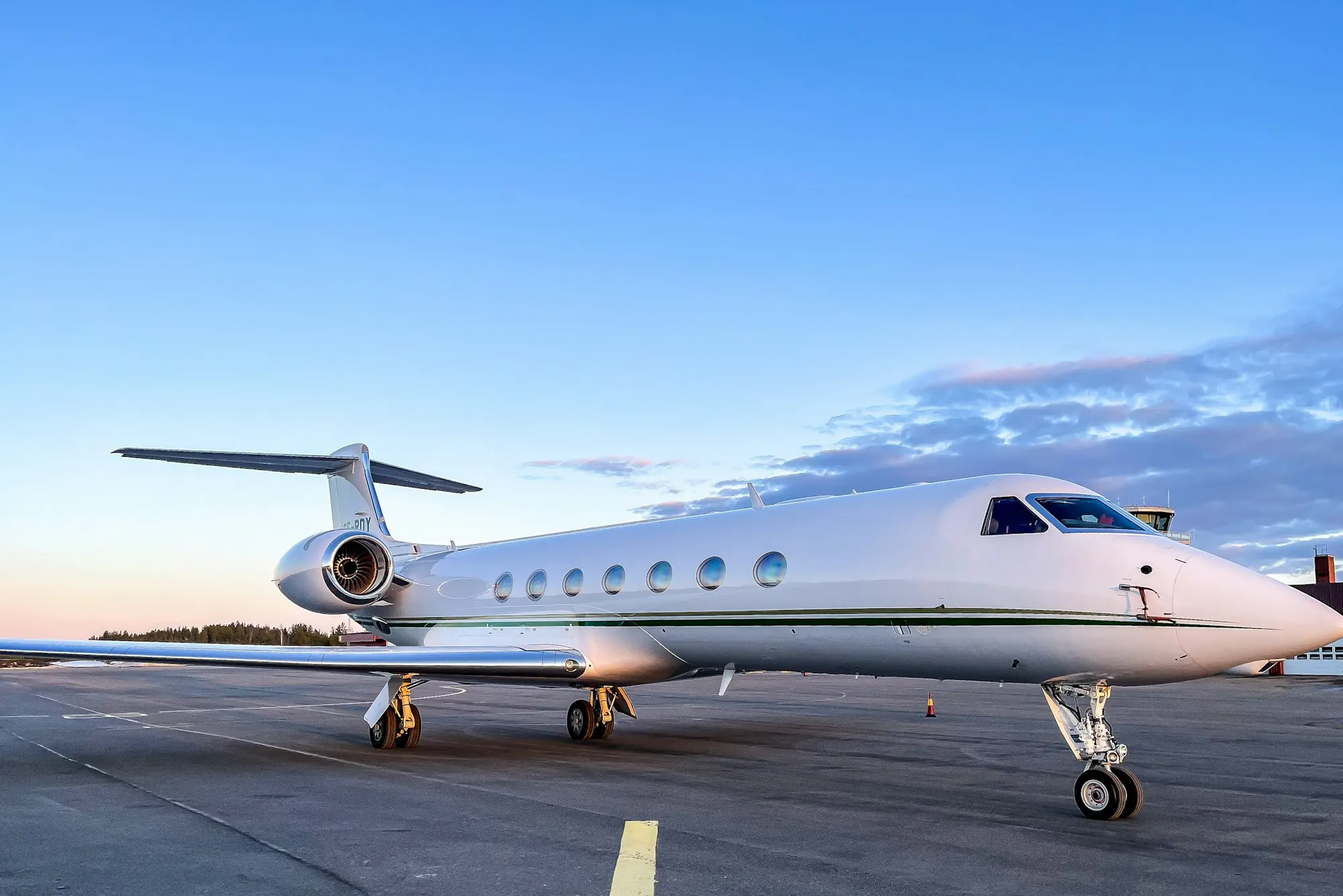 A long-range business jet parked on a sunny ramp